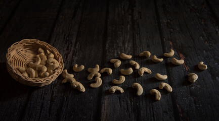 cashew nuts in basket on dark wooden table