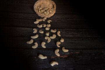 Fototapeta na wymiar cashew nuts in basket on dark wooden table