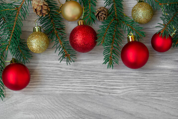 Christmas composition of fir branches, fir cones and red, gold balls on wooden boards