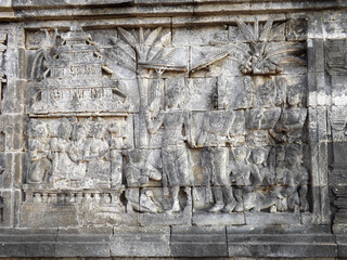 Relief panel of Borobudur temple telling about life in that era. Candi Borobudur is the largest Buddha temple located in Magelang, Central Java, Indonesia. 