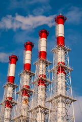 Pipes of a power plant or a plant against the blue sky.