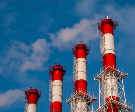 Pipes of a power plant or a plant against the blue sky.