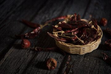 Dry red chili in basket with dark wooden background 