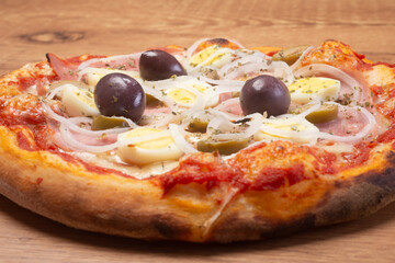 Traditional Brazilian pizza with Portuguese flavor, with mozzarella, eggs, onion, ham and olives on white background