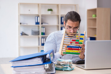 Young male bookkeeper calculating tax payments in the office