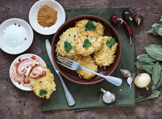 Potato pancakes are a national dish of Belarus, Ukraine and Russia.On a wooden background, pancakes, potato pancakes or pancakes, surrounded by sauce, salted fish and spices.