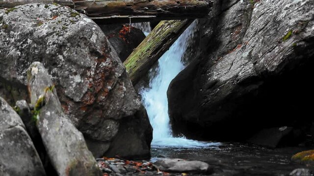Amazing mountain cascade flowing through the rocks in autumn time