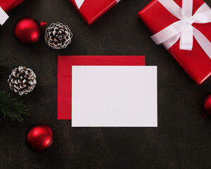 Blank white greeting card and envelope mockup with christmas gifts decorations on grunge background.