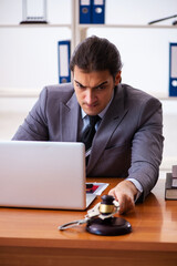 Young male lawyer sitting in the office