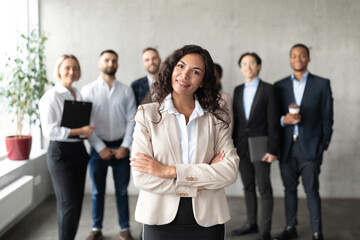 Fototapeta na wymiar Businesswoman Standing In Front Of Her Employees Posing In Office
