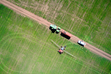 Treatment of the field with herbicides. A tractor with a spray gun drove up to a tractor with a...