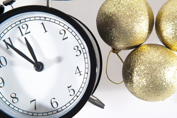 Golden glass Christmas balls with an alarm clock isolated on a white background. Close up
