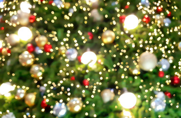 Obraz na płótnie Canvas close up of defocused christmas tree with lights glowing. decorated christmas tree by shiny ornaments with glittering mood background. celebration concept background.