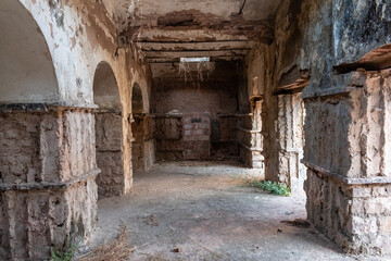 Obraz premium Bhopal, Madhya Pradesh, India - March 2019: Dilapidated columns inside an arcaded hall inside an ancient ruined building in the old city of Bhopal.