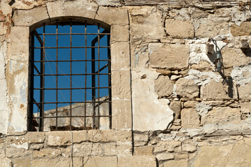 Barred window in old stone wall