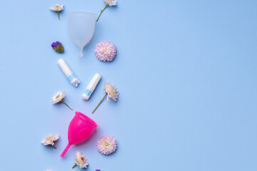 Menstrual hygiene products with flowers on blue background