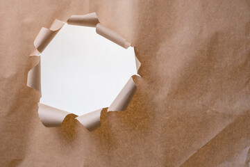 A hole in the crumpled brown wrapping paper