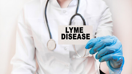 The doctor's blue - gloved hands show the word LYME DISEASE - . a gloved hand on a white background. Medical concept. the medicine