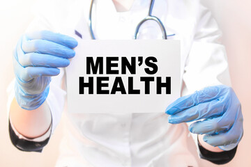 The doctor's blue - gloved hands show the word MEN'S HEALTH - . a gloved hand on a white background. Medical concept. the medicine