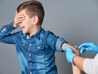 Young boy crying while being vaccinated
