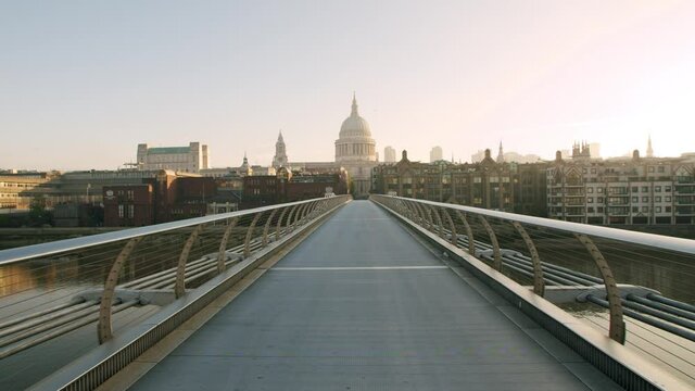 Lockdown in London, cinematic sunrise gimbal walk along completely empty Millennium Bridge with St Pauls Cathedral in the background, during the COVID-19 pandemic 2020.
