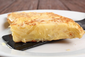 Piece of Spanish omelette on plate. Macro.