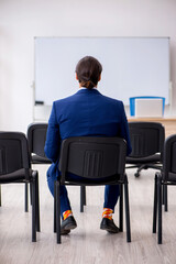 Young male business trainer in the office during pandemic