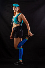 Fototapeta na wymiar girl in blue jogging uniform runs in the studio on a black background