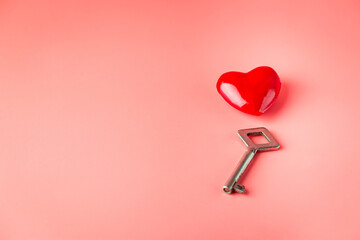 Key with a heart as a symbol of love. Valentines day background. Greeting card with red heart on pink background