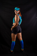 Beautiful redhead girl in jogging uniform posing in studio on black background