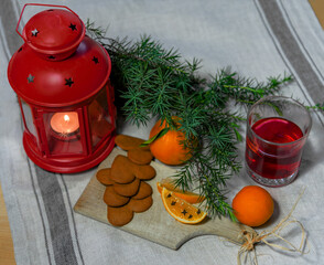 Christmas composition with candle, juniper branch and glass of juice