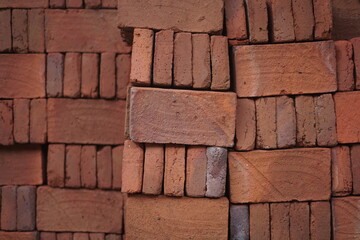 neatly arranged pile of bricks, looks like abstract wallpaper. red color on the brick with a border on each part.