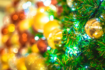 Obraz na płótnie Canvas Selective focus Christmas tree with holidaygold ball and lights with copy space on blurred bokeh background.