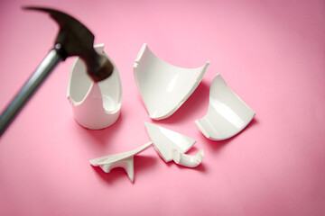 A hammer smash on broken white cup with few little pieces, concept disintegration