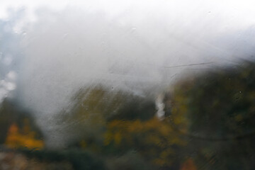 Looking through the glass of the car during a thunderstorm in autumn, in the background Italian countryside
