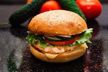 Homemade cheeseburger made from turkey. The ingredients used were poultry breast, cucumber, tomato, lettuce, cheese and sauce.
