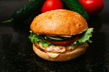 Homemade cheeseburger made from turkey. The ingredients used were poultry breast, cucumber, tomato, lettuce, cheese and sauce.