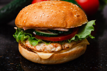Homemade cheeseburger made from turkey. The ingredients used were poultry breast, cucumber, tomato, lettuce, cheese and sauce.