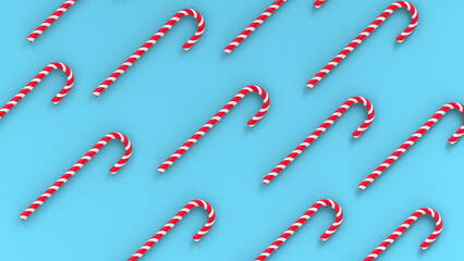 Mint hard candy canes striped in Christmas colours isolated on a blue  background. 