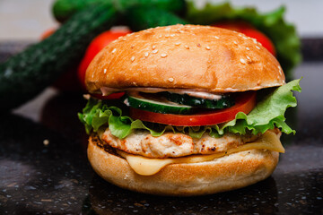 Homemade cheeseburger made from turkey. The ingredients used were poultry breast, cucumber, tomato, lettuce, cheese and sauce.