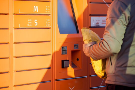 Man using automated self service post terminal machine or locker.