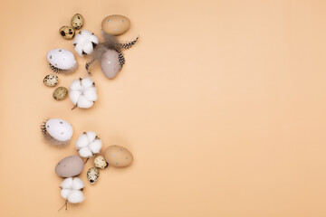 Easter eggs on beige pastel background with space for text. Flat lay image composition, top view.