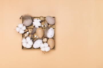 Easter eggs on beige pastel background with space for text. Flat lay image composition, top view.