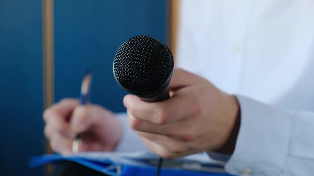 Correspondent or journalist interviewing and writing something down in a notebook. Press conference
