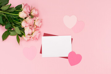 Pink paper hearts and flowers roses on pastel pink background. Valentines day concept. Flat lay, top view, copy space.