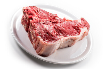 Raw T-bone steak on white round plate