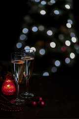two glasses of champagne on a dark background with bokeh