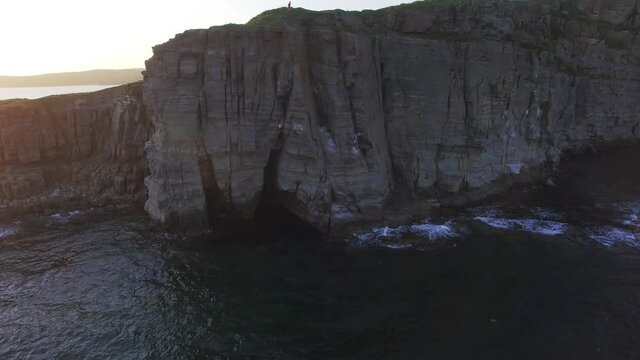 Drone view of a beautiful peninsula Tobizina with vertical cliffs at sunset.