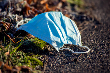 Used medical face masks on ground on the street. Environmental pollution concept