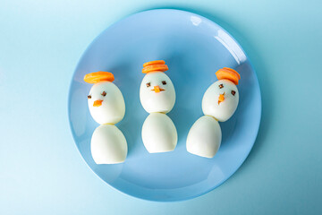 Appetizer from boiled eggs and carrot. Funny snowmans. Kid's menu for Christmas and New Year.